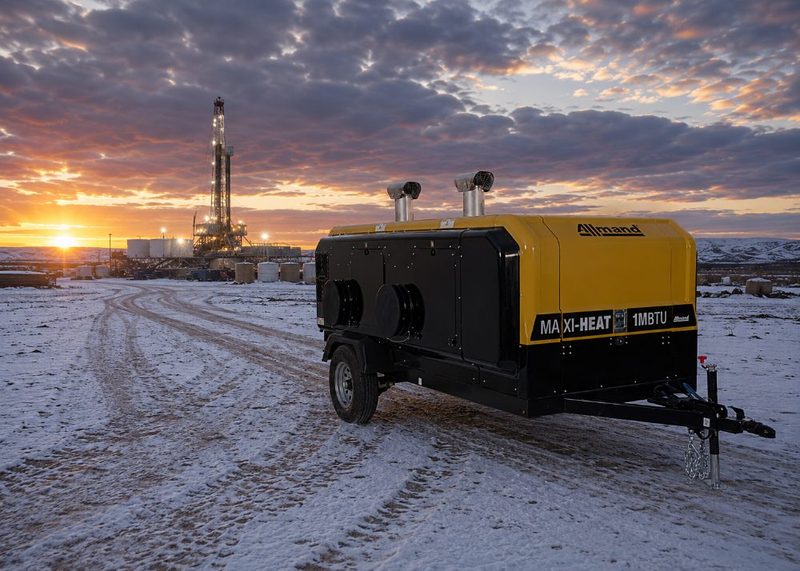 Allmand Maxi-Heat indirect-fired heater on a snowy oilfield at sunset